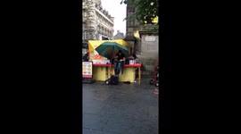 Street performing Musician playing in the poring rain at Edinburgh's annual festival fringe 2015