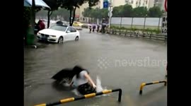 Woman falls into deep floodwaters