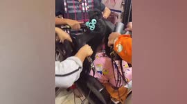 3 hairdressers help each other straighten customer hair