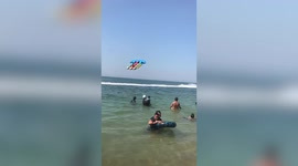 Inflatable boat with tourist floats in air while attached to running speedboat