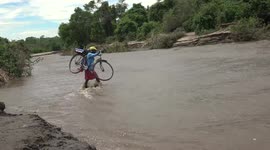 People carry things across the flooded part of the region in Lilongwe, Malawi