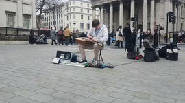 Talented guitarist with an unusual playing style busks in London's Trafalgar Square
