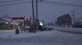 Post Road in Norwalk, Connecticut during winter blizzard and windy conditions with snow plow truck