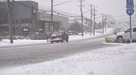 Traffic on Post Road during winter blizzard on US East Coast, with slippery and snow-covered road