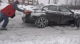 Man pushes car in Norwalk, Connecticut as powerful Winter Storm Kenan slams into eastern US
