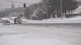 Traffic on Post Road during  Winter Storm Kenan on US East Coast, with slippery and snow-covered road.