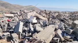 Palestinian men inspect the debris his house in the village of Al-Aqaba, to the east of Tubas