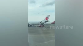 Airport worker hurls boxes down boarding stairs of plane in Indonesia