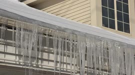 As spring gets closer and the sun gets stronger the snow is melting and icicles are forming and causing damage to gutters and signs as the heavy ice hangs on the edges of roofs in Waterloo Ontario Canada