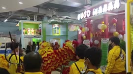 Lion dance picking up red packets at a shopping center in Palembang
