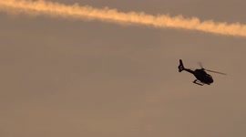 Helicopter taking off at London Heliport at sunset - view from Fulham