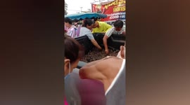 Thai locals swarm around food vendor selling live bullfrogs
