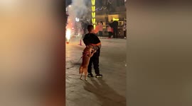 Scared dog hides behind owner as fireworks set off on road in China
