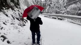 Father carries 15kg suitcase for daughter along snow-covered road in China