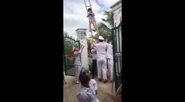 Jaw-dropping stunt sees man use his mouth to lift ladder with girl on
