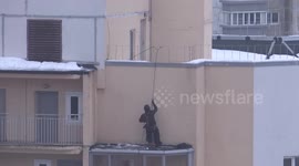 'Spidermen' suspended by rope clear snow from rooftops in St Petersburg