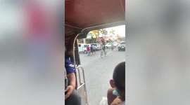 Cyclist rides tall bike on a road in the Philippines