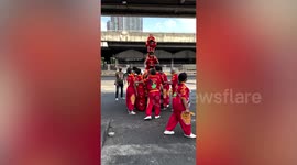 Brave toddler stands on top of human tower during Chinese New Year celebrations