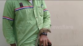 Indian man has squirrel sidekick that clings to him as he rides motorbike