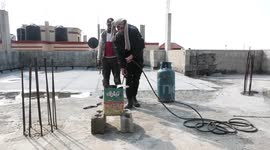 Palestinians workers lay layer of water resistance against leakage caused by rain water on the roof of the houses
