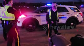 Two dads with their kids kneel before police at 'Freedom Convoy' rally in Canada