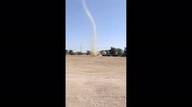 Fearsome dust devil swirls across open field in Sivlakha in Gujarat, India