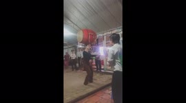 Brave woman balances a giant drum on a glass on her head in Vietnamese street circus