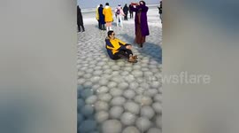 Huge bubbles of ice resembling dumplings sit underneath frozen lake in China