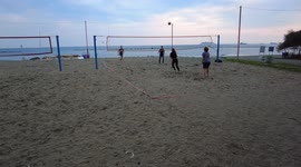 Children play beach volleyball on the beach. Winter, cloudy weather in Cyprus.