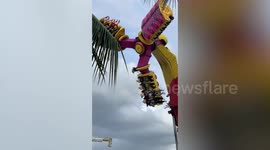Terrifying moment revellers hang upside down on jammed fairground ride