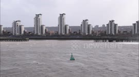 The winds from Storm Eunice kick up clouds of spray from the River Thames in London