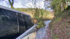 Branch blocking the road gets pulled during storm Eunice to unblock the road whilst storm chasing. STORM CHASERS OF UK WEATHER CHASE INTERCEPT STORM EUNICE IN CORNWALL WITH WINDS UP TO 100MPH CAUSING LARGE AMOUNTS OF DAMAGE WITH RED WARNING