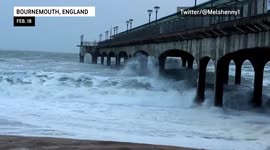 Stormy waves crash against Boscombe Pier, moving sand from Storm Eunice
