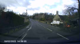Two unsuspected people in a car is almost hit by a large branch which falls during storm Eunice, near Castle Combe