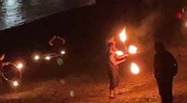Group of people perform fire dance on Southbank of River Thames