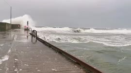 Waves crash over a pier in Quilty as Storm Franklin moves on from Ireland