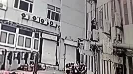 Chinese teen holds up toddler hanging out of first-floor window