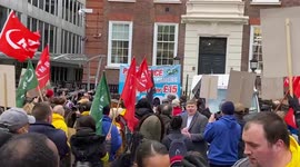 Striking railway cleaners gather outside transport company offices demanding fair pay