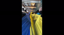 Anti-war protestors march through New York with large Ukrainian flag while singing national anthem.