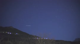 Train of Starlink satellites soar across night sky above Swiss Alps
