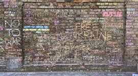 Anti-Putin and pro-Ukraine messages cover the wall at the Russian Embassy in London