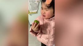 Toddler winces as she tries sour green plum for the first time