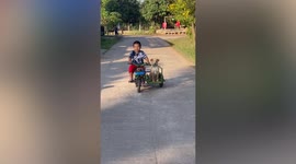 Boy drives pet dog around on modified bicycle