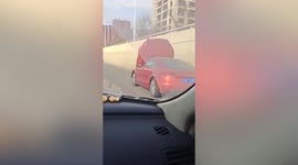 Motorist drives along road in China with view seemingly blocked by open bonnet