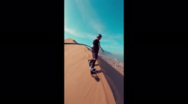 Daredevil slides down sand dune named 'Dragon Hill' for its sheer size