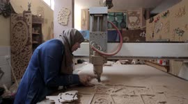Samah Shaheen, a girl working on wood engraving using a computer