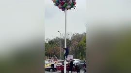 Chinese vendor attempts to climb pole after accidentally letting balloons go
