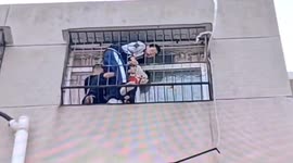 Boys rescue toddler hanging from 5th-floor window in central China