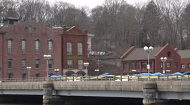 Bridge over Saugatuck River in downtown with yellow and blue ribbon like symbol for Ukraine war crisis in windy day.