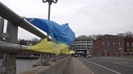 Bridge over Saugatuck River in downtown with yellow and blue ribbon like symbol for Ukraine war crisis in windy day.